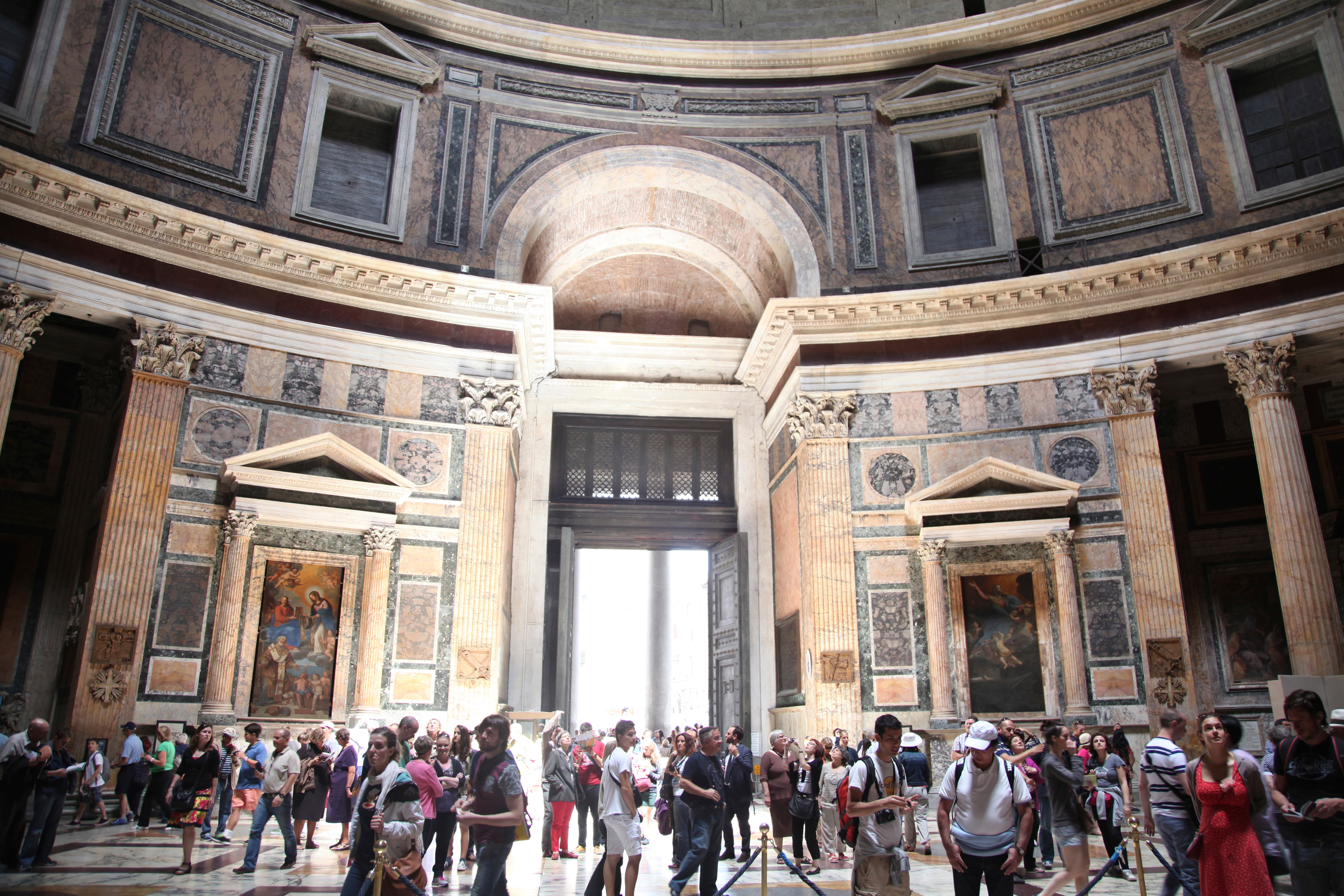 Besøkende utforsker interiøret i pantheon i Roma, med sin ikoniske store kuppel og intrikate arkitektoniske detaljer