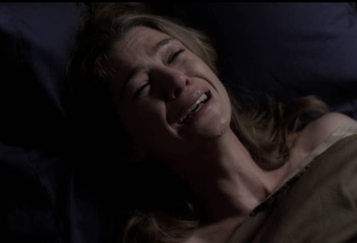 Ellen Pompeo lying down in bed, gazing upward, with tears on her face