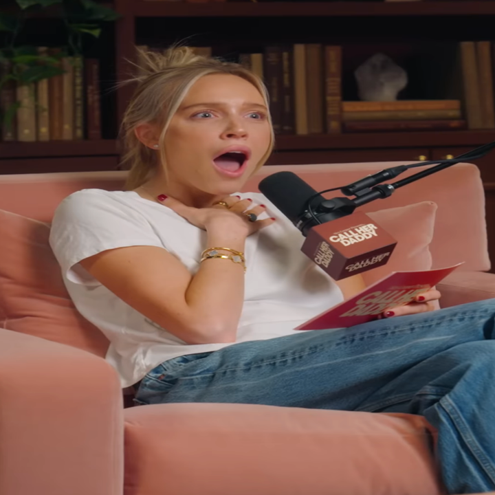 Alex Cooper with a surprised expression, speaking into a microphone