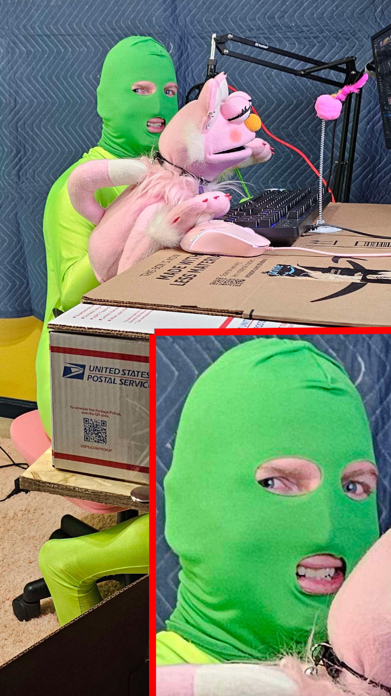 Person successful  a greenish  bodysuit with pinkish  plush unicorns, sitting adjacent   a machine  setup and cardboard box. Expression is playful and quirky