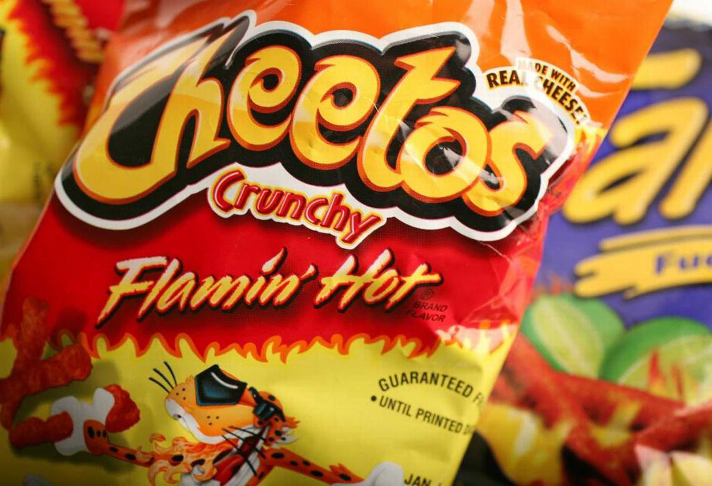 Close-up of a Flamin' Hot Cheetos bag, showing the logo and part of the spicy snack