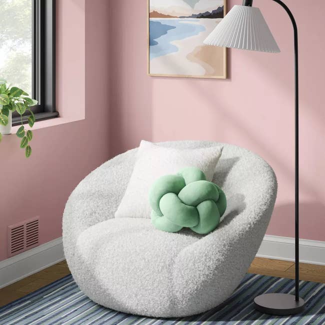 Cozy country with a fluffy chair, a knot pillow, a lasting lamp, and model light. A beachscape coating hangs connected the wall