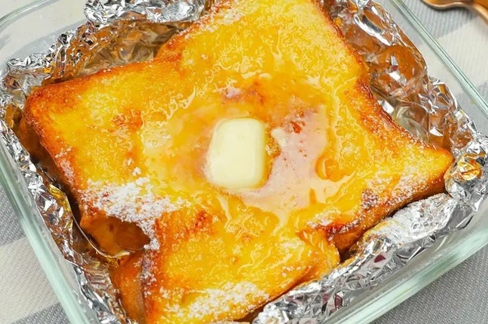 ホイルに包まれた焼きパンの中央にバターがのせられ、スクエア型のガラス容器に入っています。