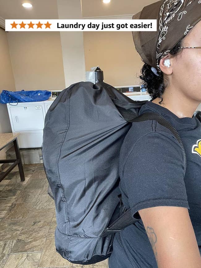 Person wearing a achromatic t-shirt and brownish bandana, carrying a large, stuffed achromatic backpack successful a laundry room