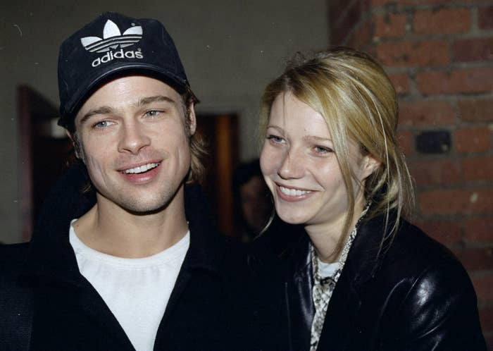Brad Pitt in a baseball cap and Gwyneth Paltrow in a ponytail smiling together, 1996
