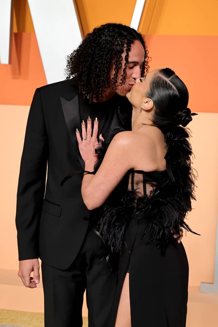 Vanessa Hudgens and Cole Tucker kissing on a red carpet