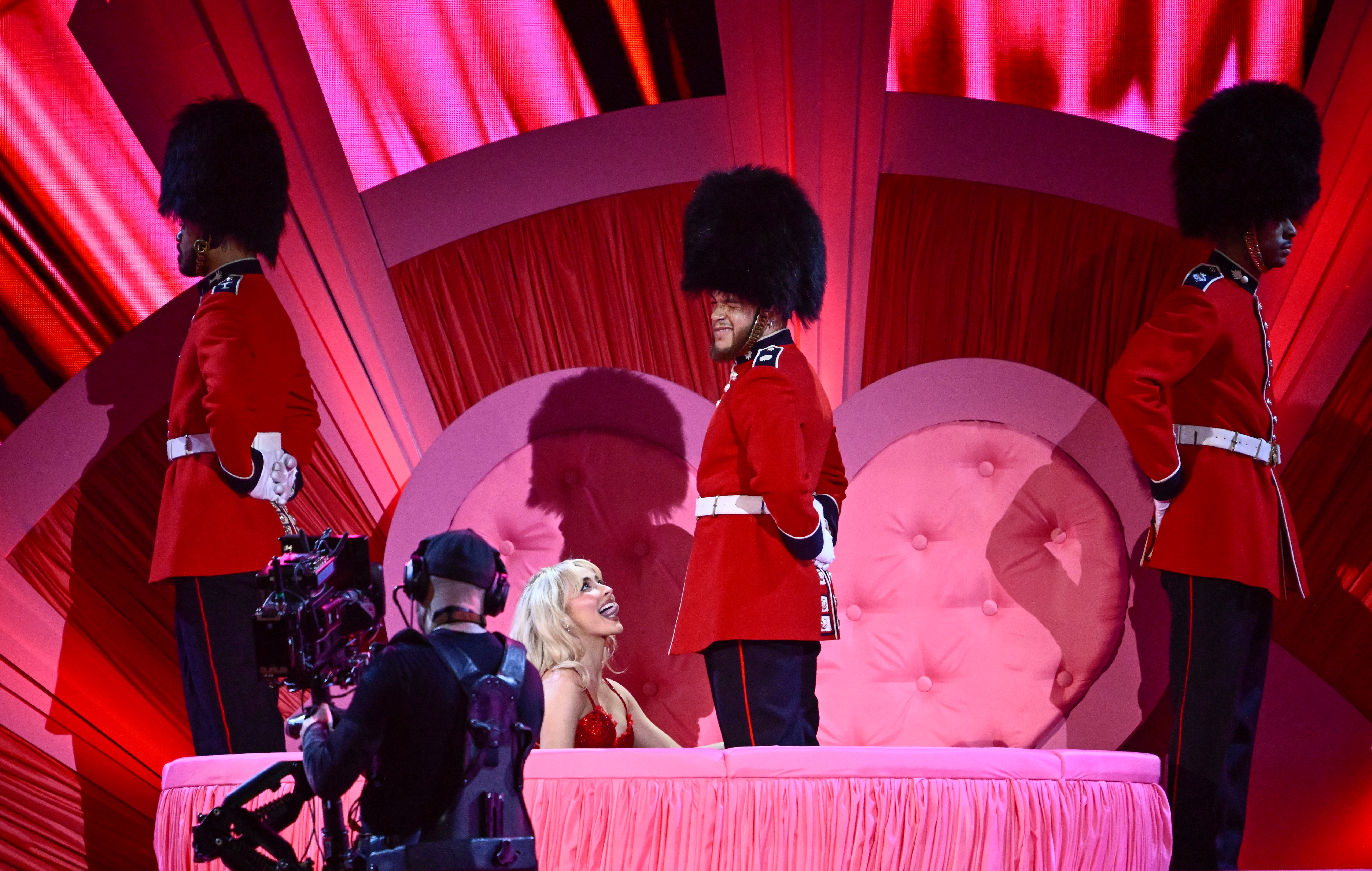 Sabrina Carpenter performing at the Brits, kneeling in front of a man dressed as a British soldier