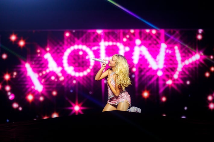 Sabrina Carpenter performs in front of the word ‘HORNY’ in lights