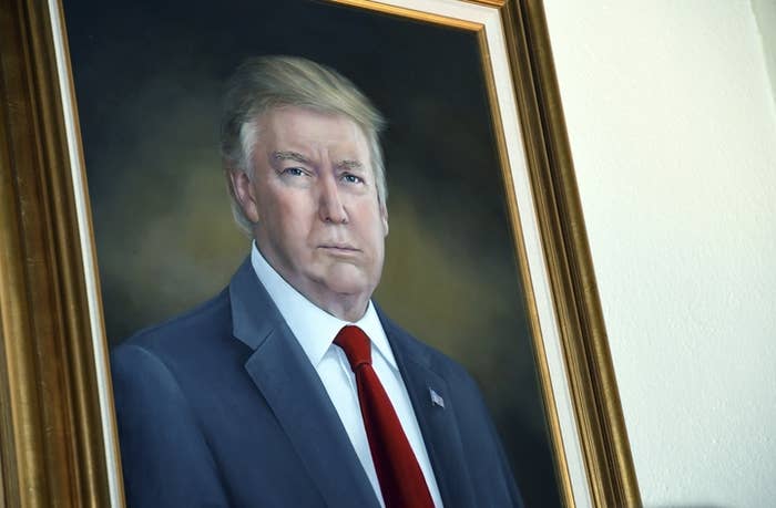 Portrait of a man in a suit and tie, captured in a formal pose with a neutral expression. The image is in a decorative frame