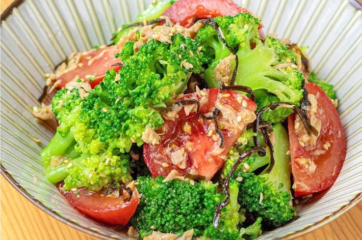 ブロッコリーとトマトのサラダ、ドレッシングがかかった食事の盛り付けです。