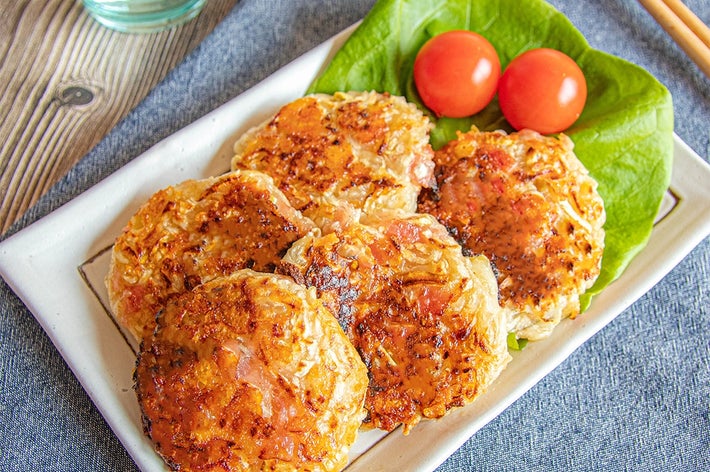 プレートにのった切り干し大根餅4個とリーフレタス、2つのミニトマトがテーブルに置かれている。