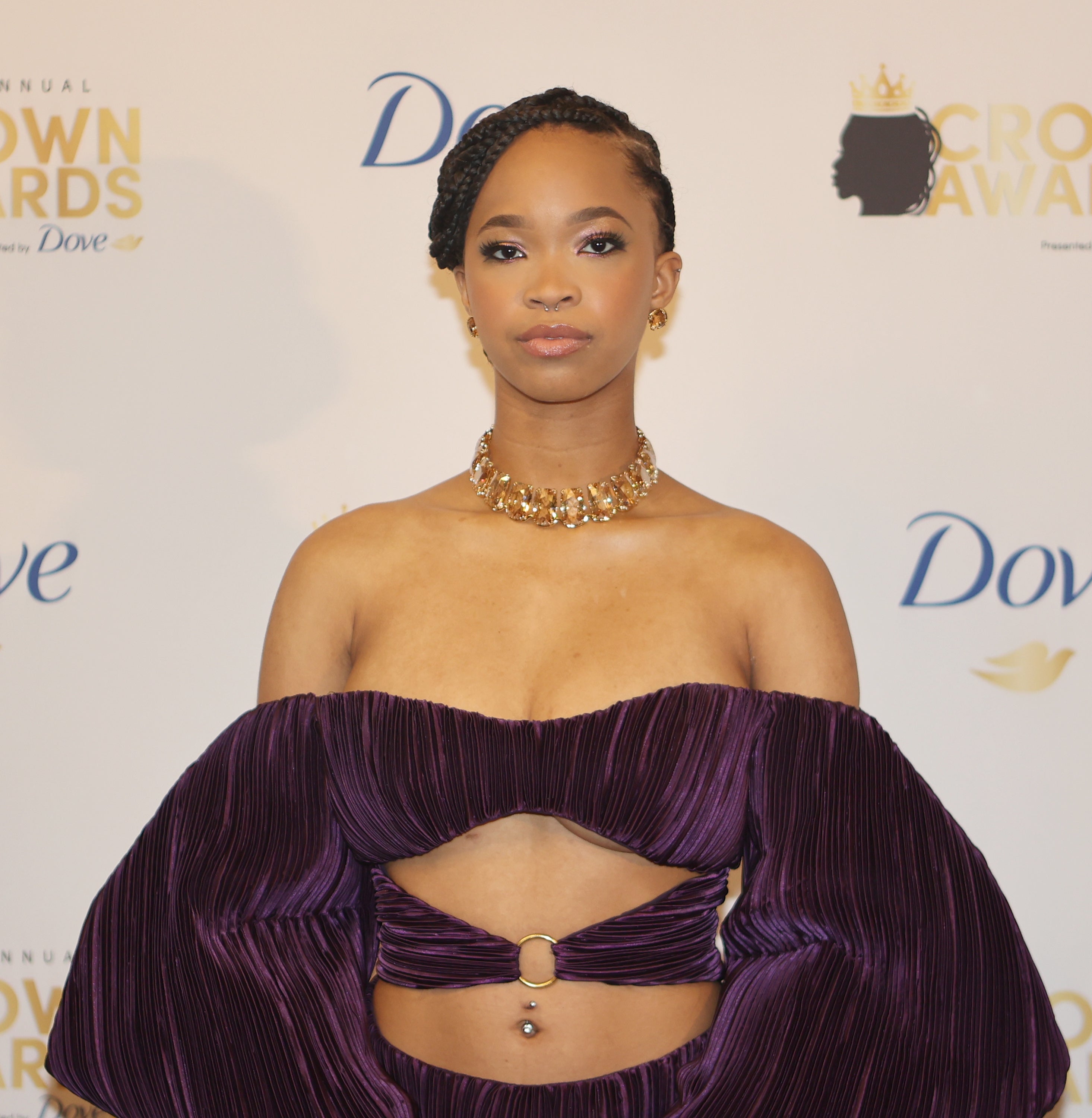 Person in an off-the-shoulder, pleated, two-piece outfit with puffed sleeves at an awards event