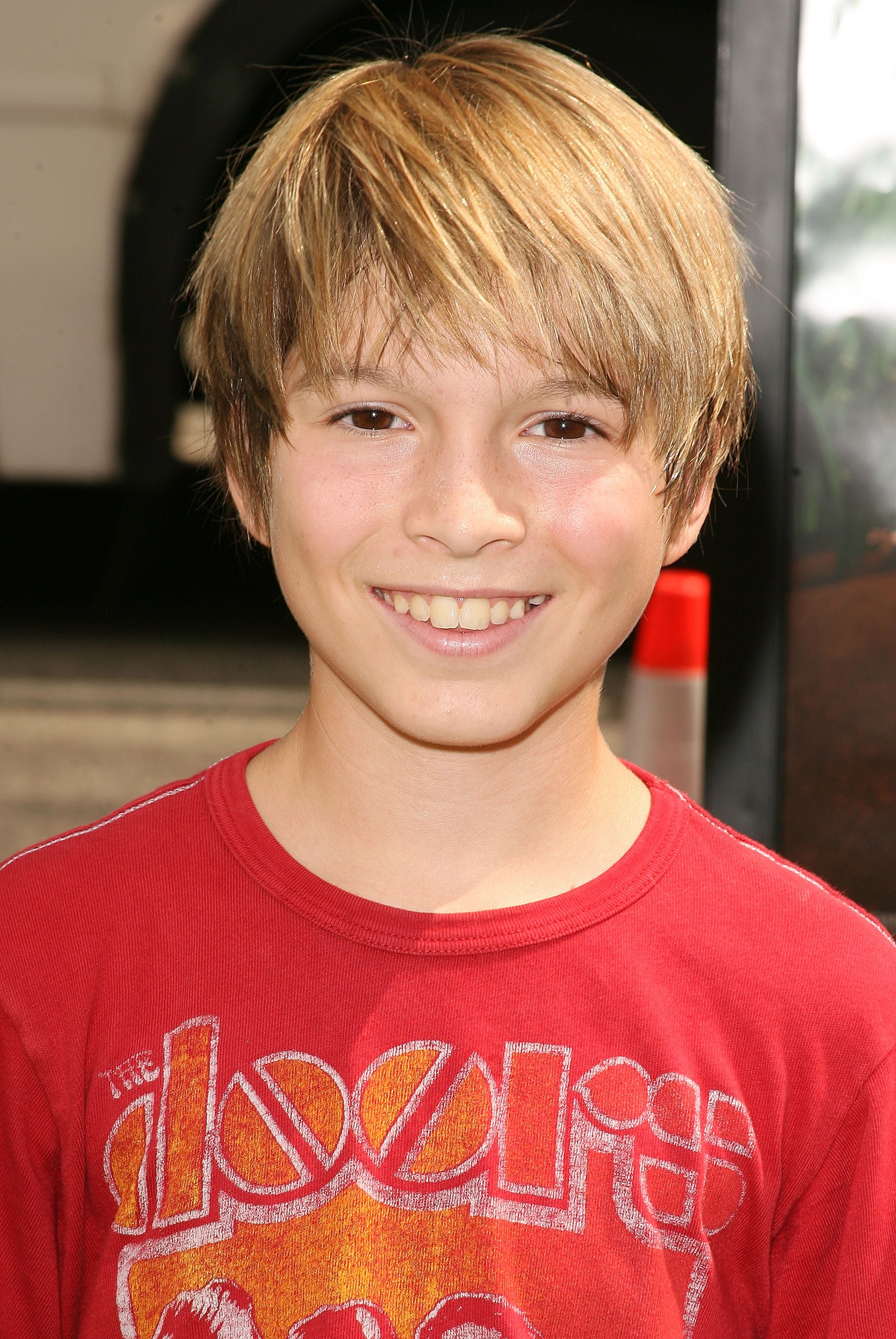 Smiling child wearing a T-shirt with a vintage band logo