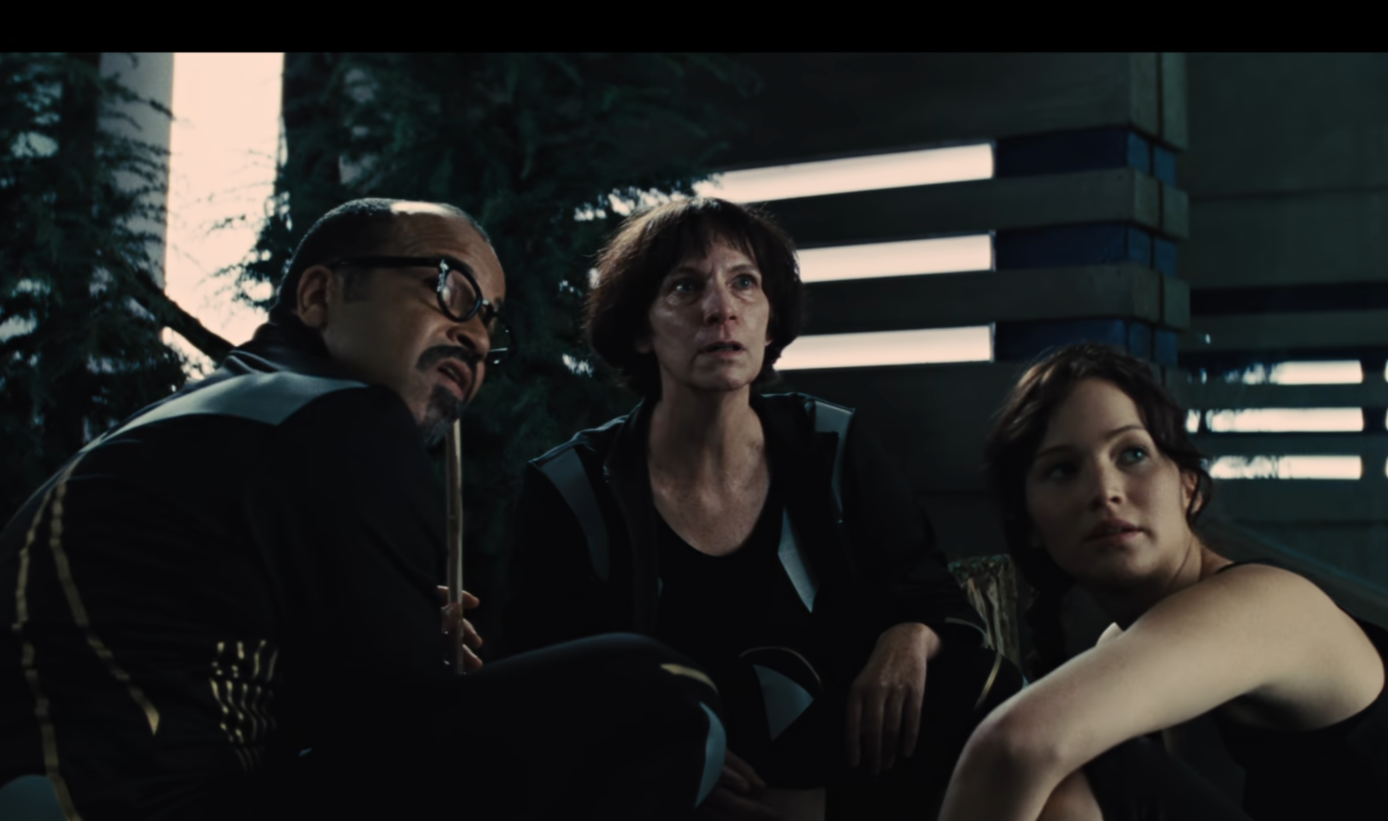 Jeffrey Wright as Beetee, Amanda Plummer as Wiress, and Katniss sitting together, appearing tense and focused in a movie scene