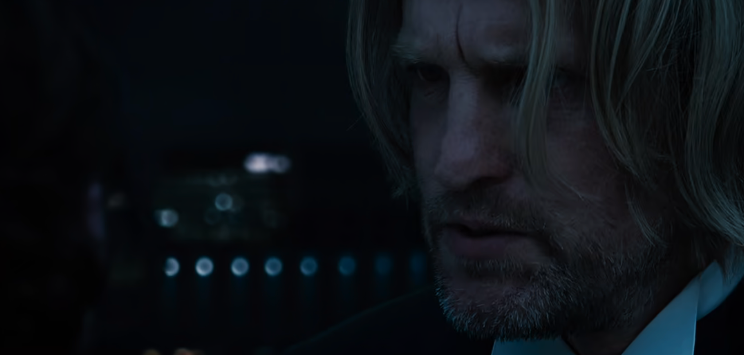 Haymitch looking intently off-screen in a tense moment from a movie scene