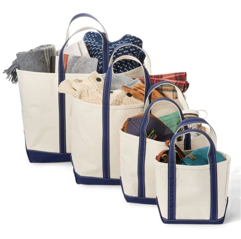 Four canvas tote bags in varying sizes are filled with folded clothes and accessories, showcasing storage versatility