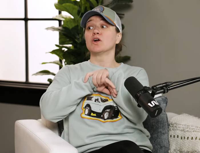 Kelly Clarkson speaking into a microphone on a podcast