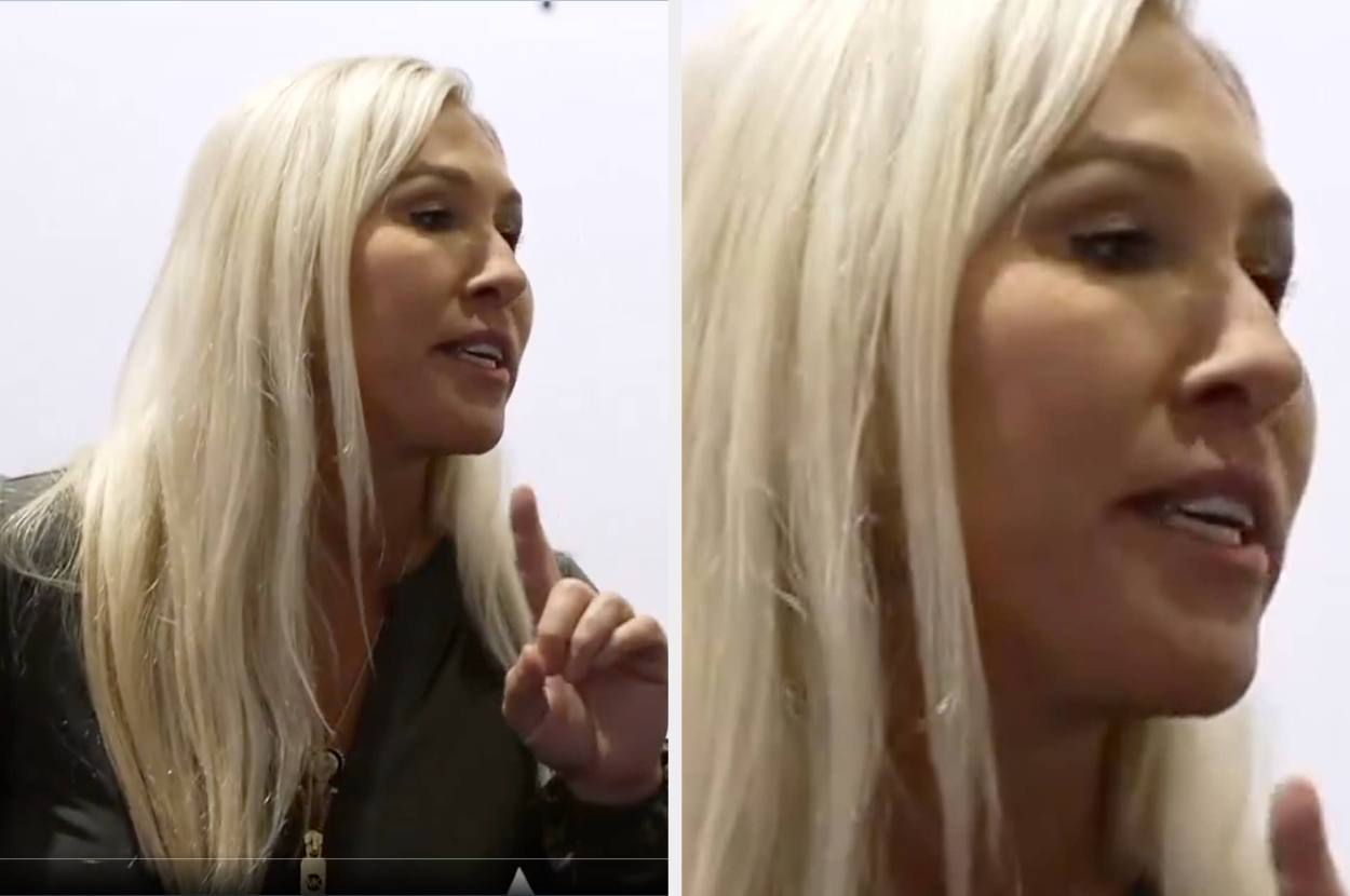 Person with light hair speaking, wearing a buttoned, dark top. They are gesturing with their hand