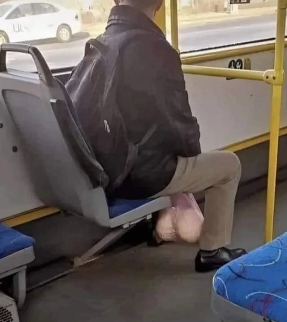 Person sitting connected  a autobus  spot   with a backpack, carrying a integrative  container  connected  their lap. The autobus  interior is visible