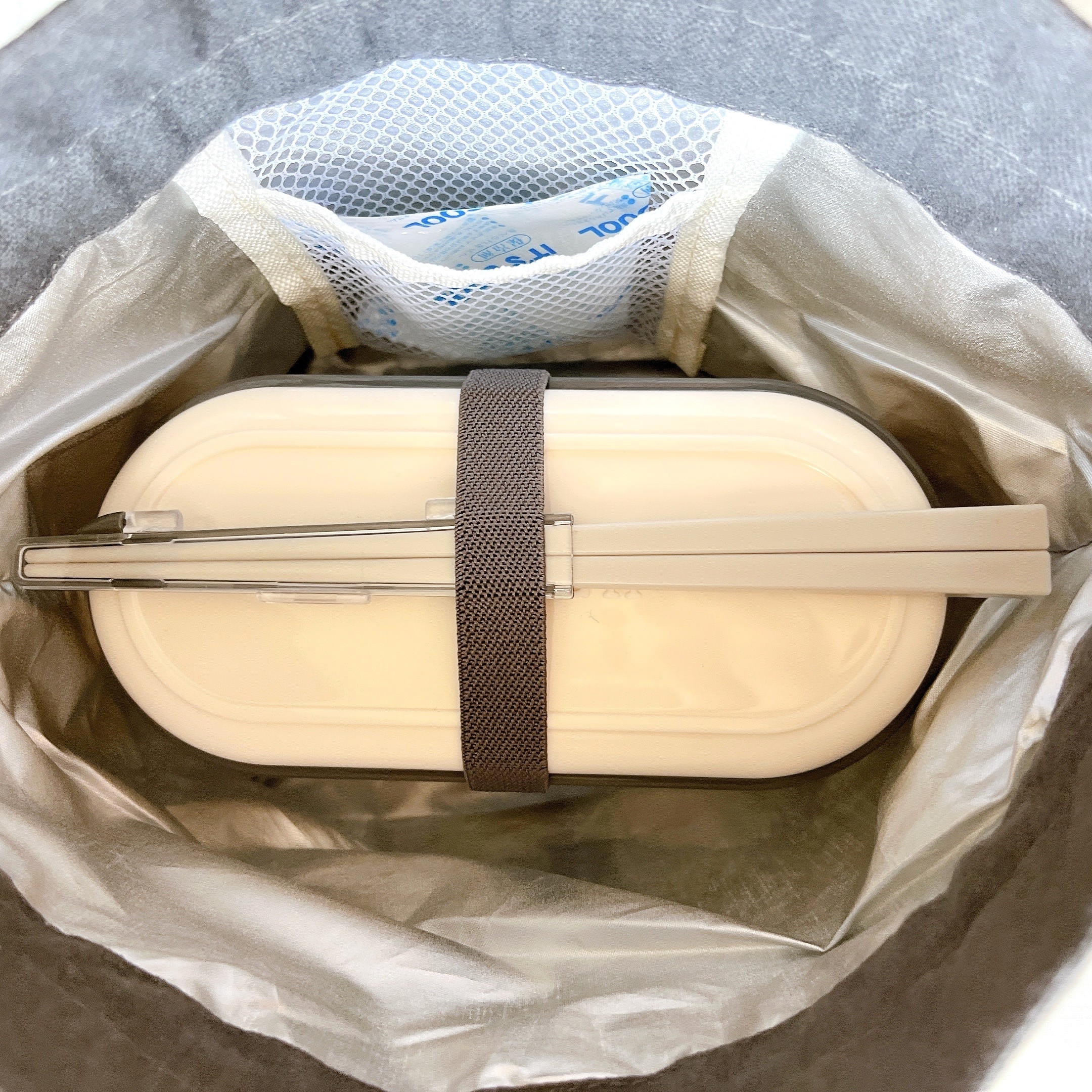 カバンの中に収納されたスリムな弁当箱。蓋に箸が固定されています。