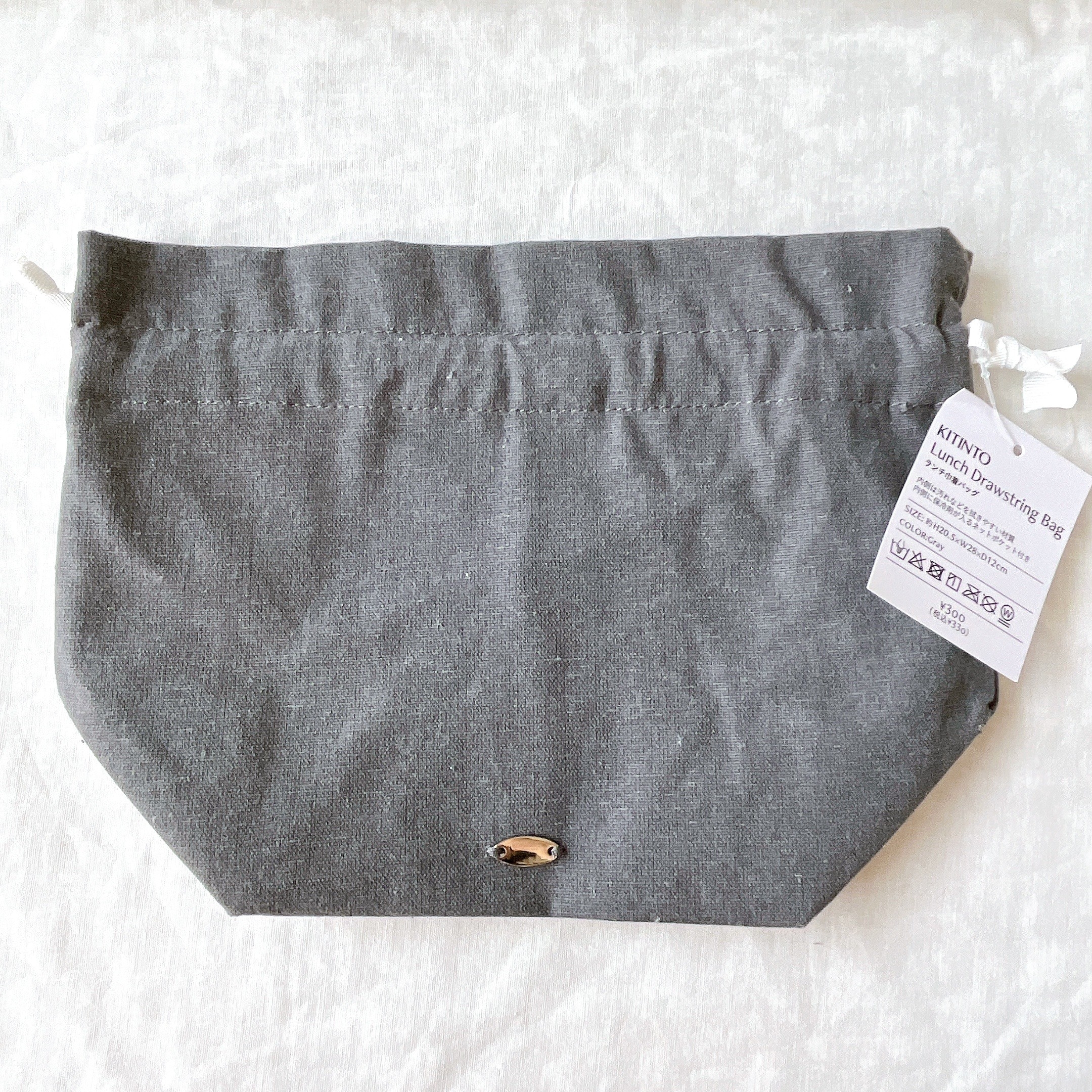 キントーのリネンドローイングバッグが平らに置かれている。白いタグ付き。