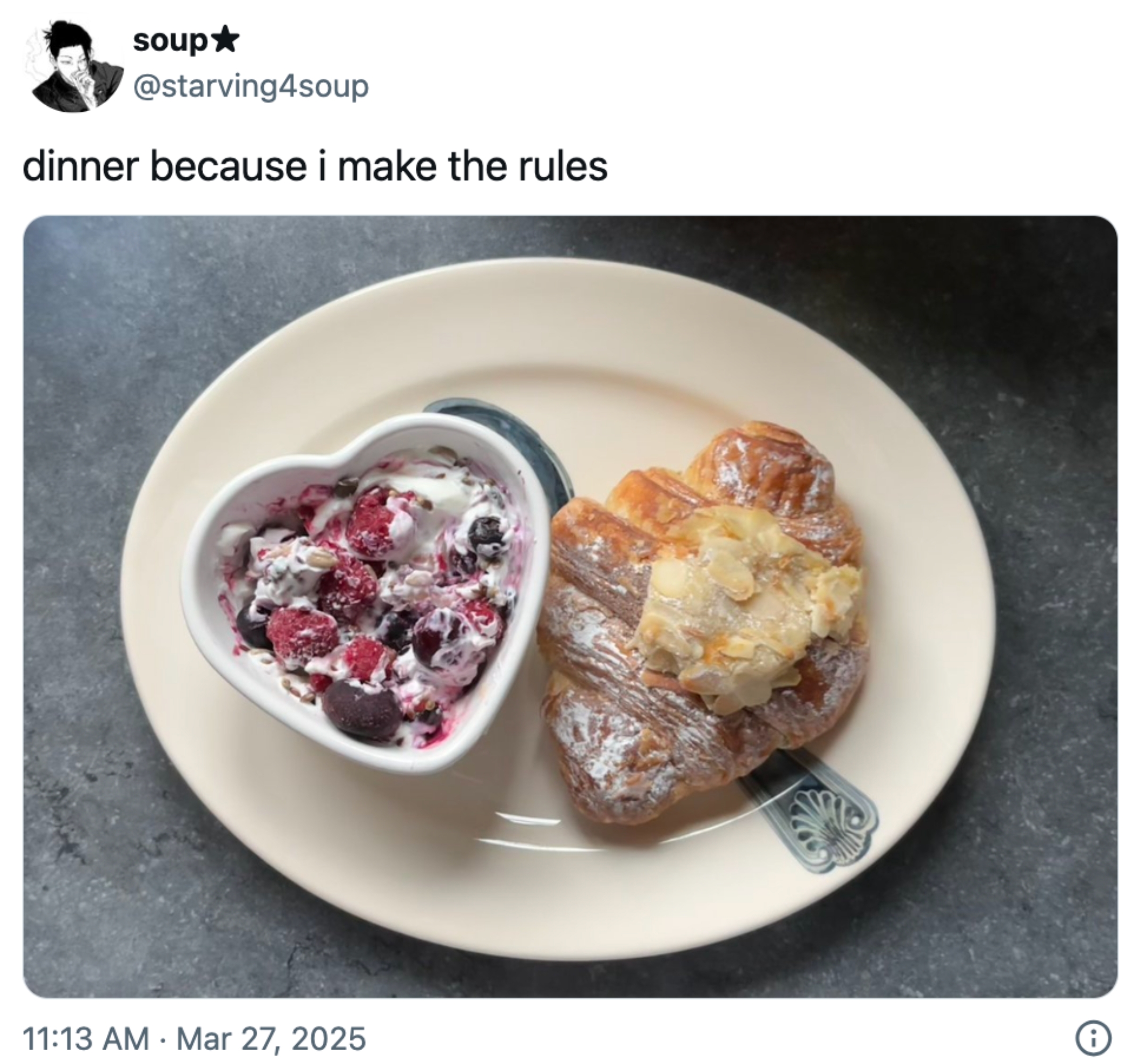 Hjerteformet skål med yoghurt med bær og en croissant på en tallerken, skrevet 
