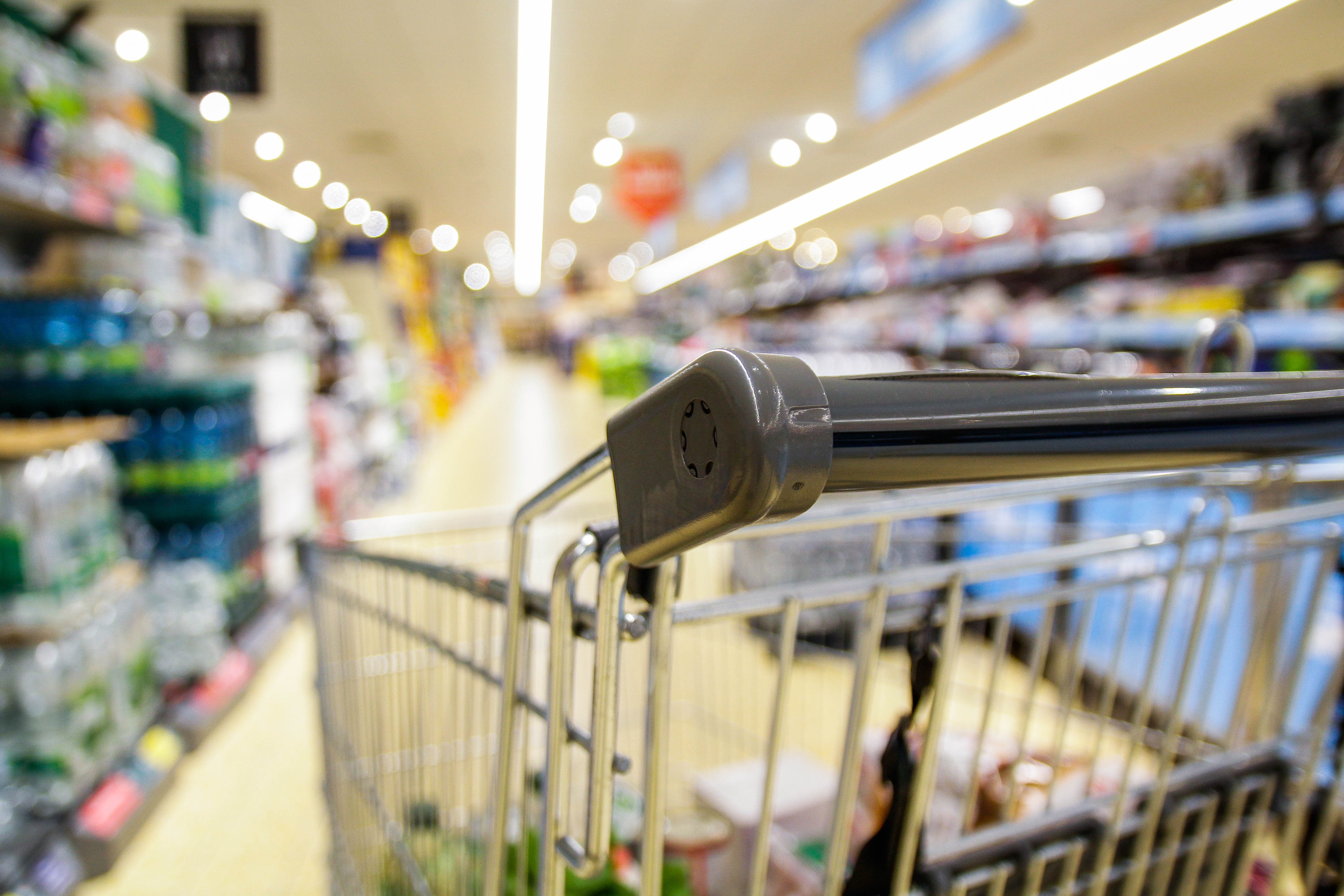 Shopping cart in a grocery store aisle.