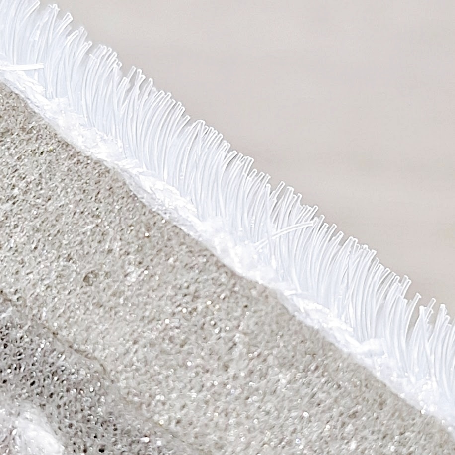 滑り止め加工されたラグの端のクローズアップ写真。縁には丈夫なステッチがあります。