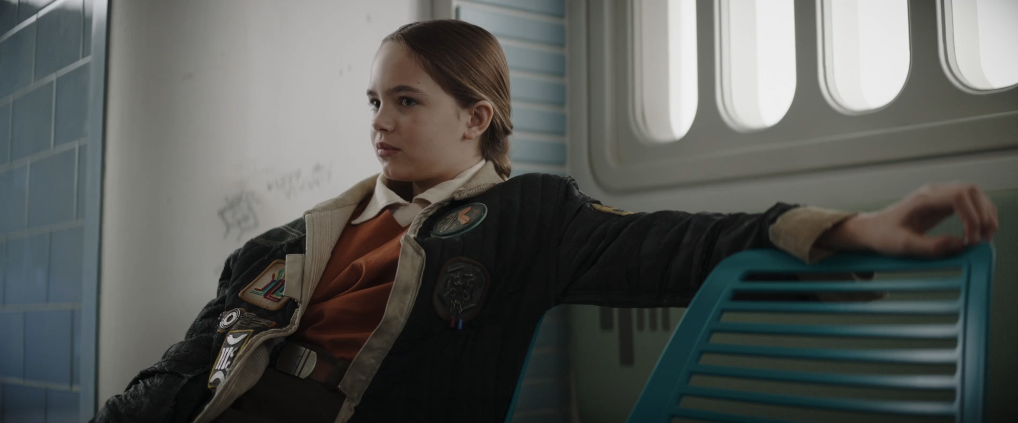 A young girl in a jacket covered in patches in a scene from &quot;Star Wars: Skeleton Crew&quot;