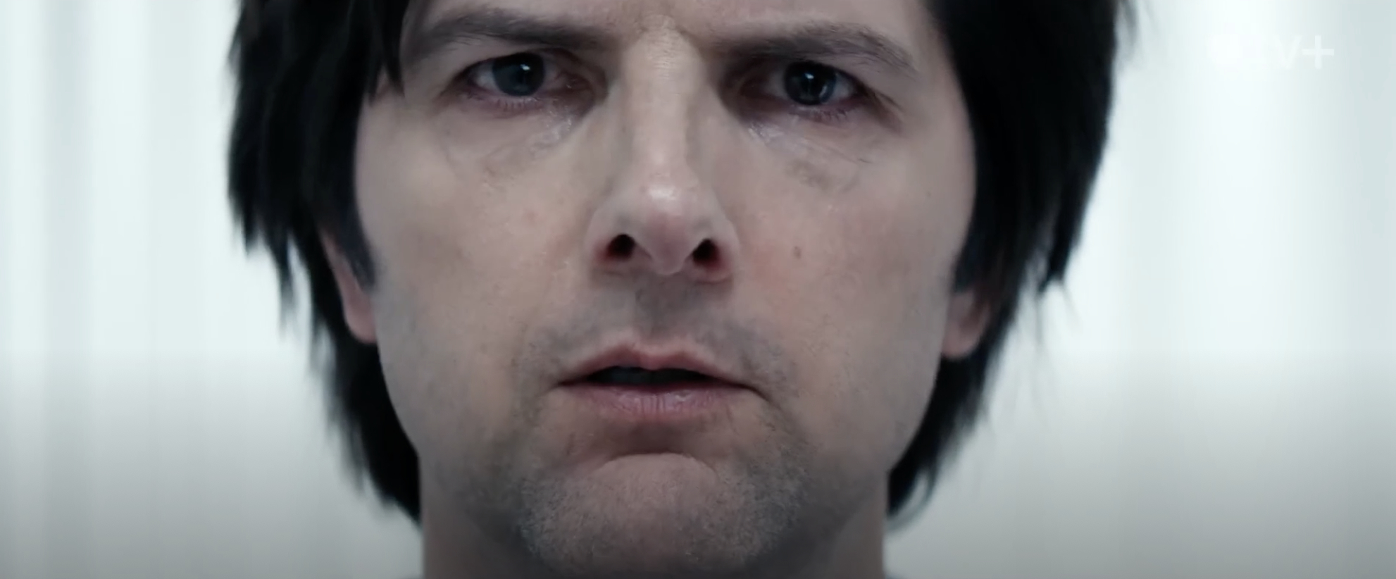 Adam Scott stares into the distance against a white background during a scene in &quot;Severance&quot;