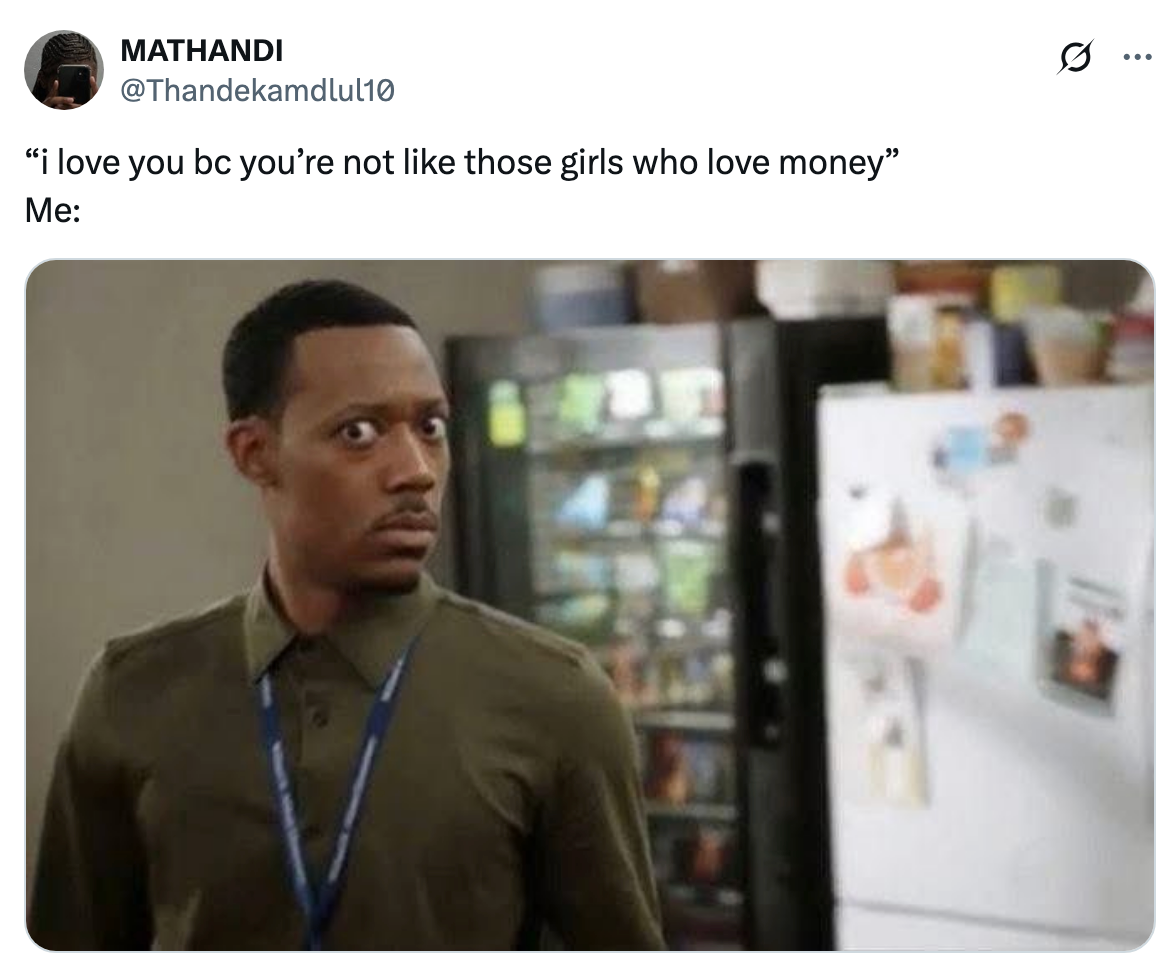 Man in a khaki shirt looking surprised in a kitchen. Tweet text above: "I love you bc you’re not like those girls who love money." Me: (Image of the man)