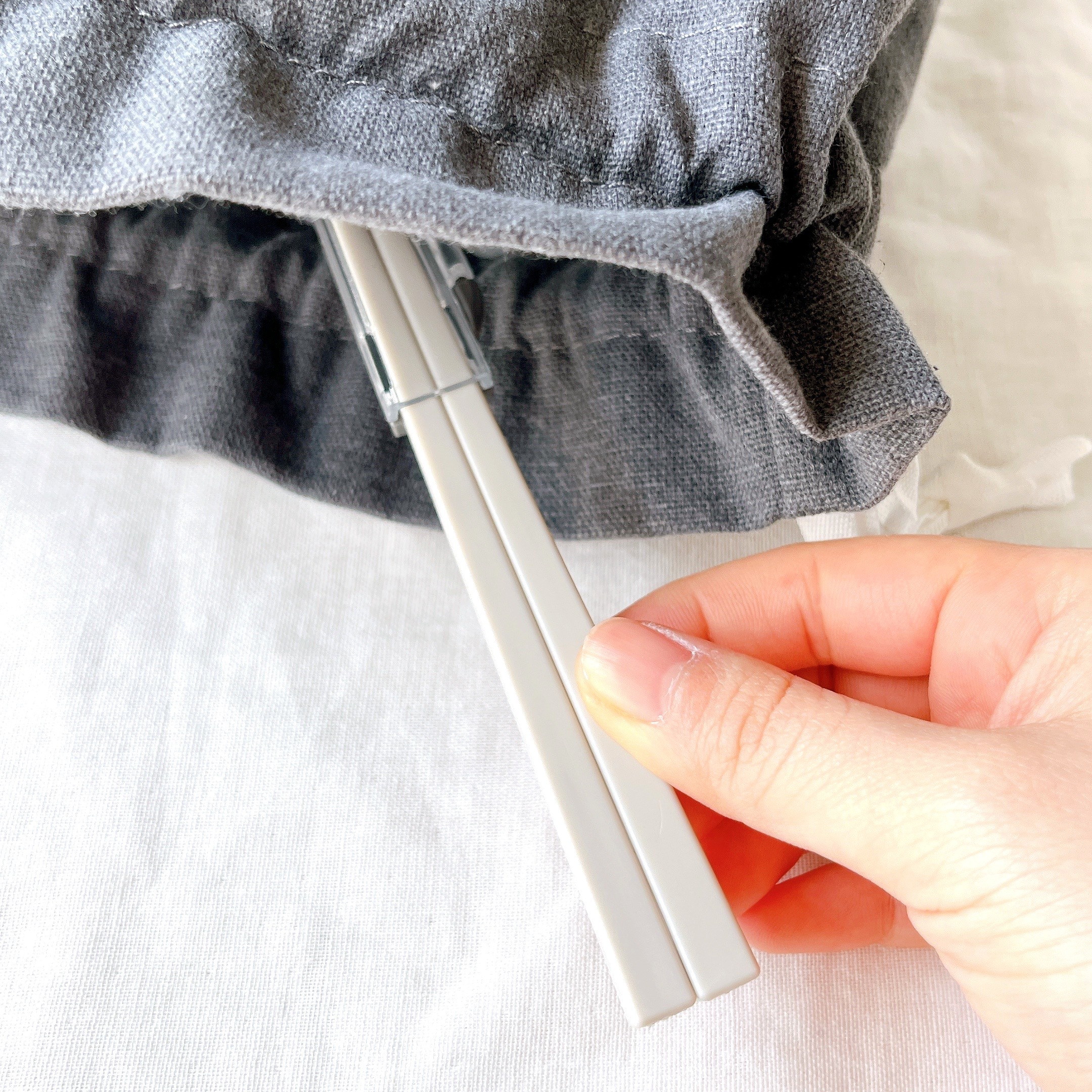 布団カバーをクリップで固定する手。