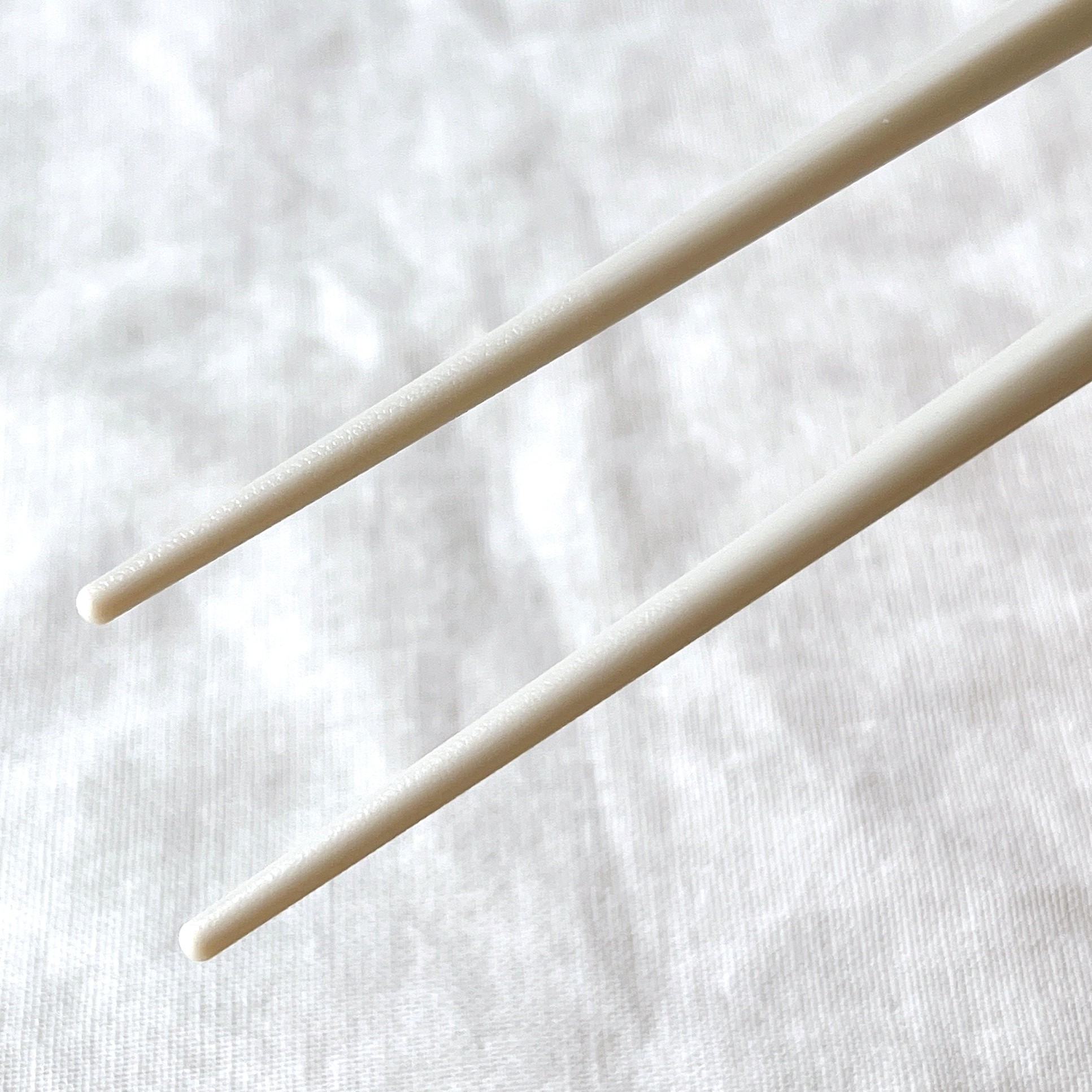 布の上に置かれた2本の箸のクローズアップ写真。