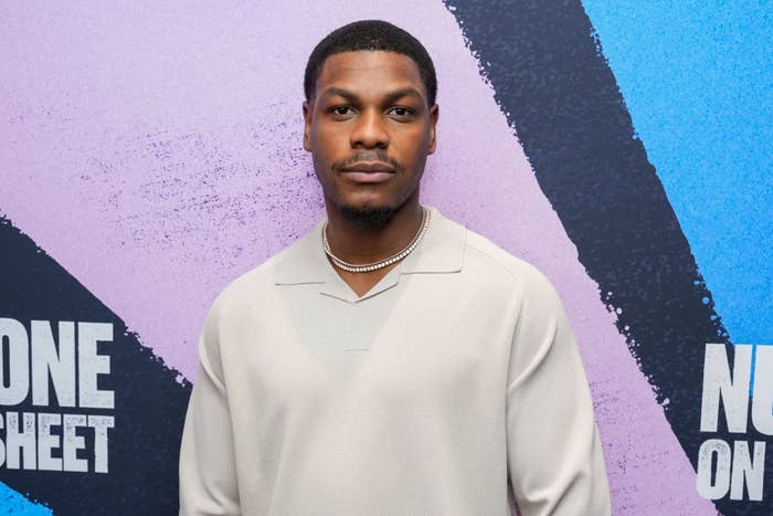 Man in a light shirt standing in front of a graphic backdrop at an event