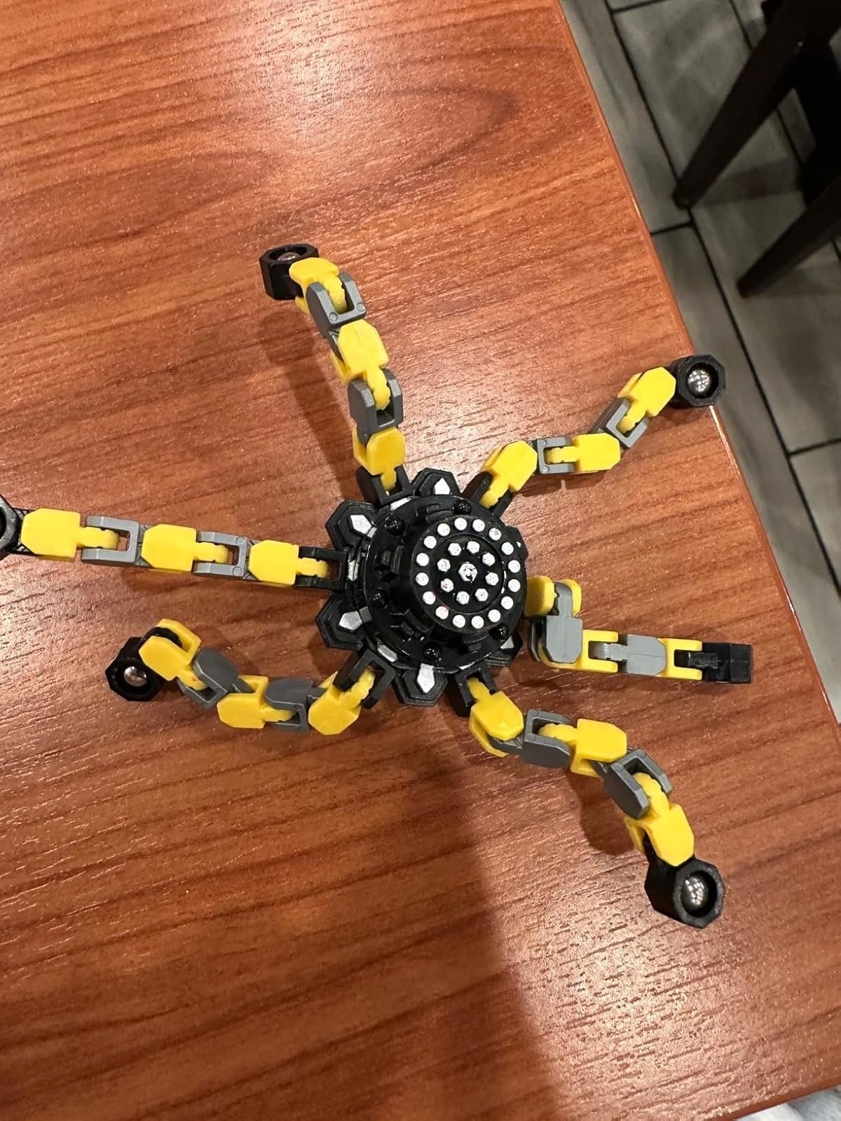 fidget toy with jointed legs displayed on a wooden table