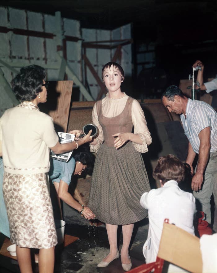 Julie Andrews behind the scenes of "The Sound of Music" being styled by crew members
