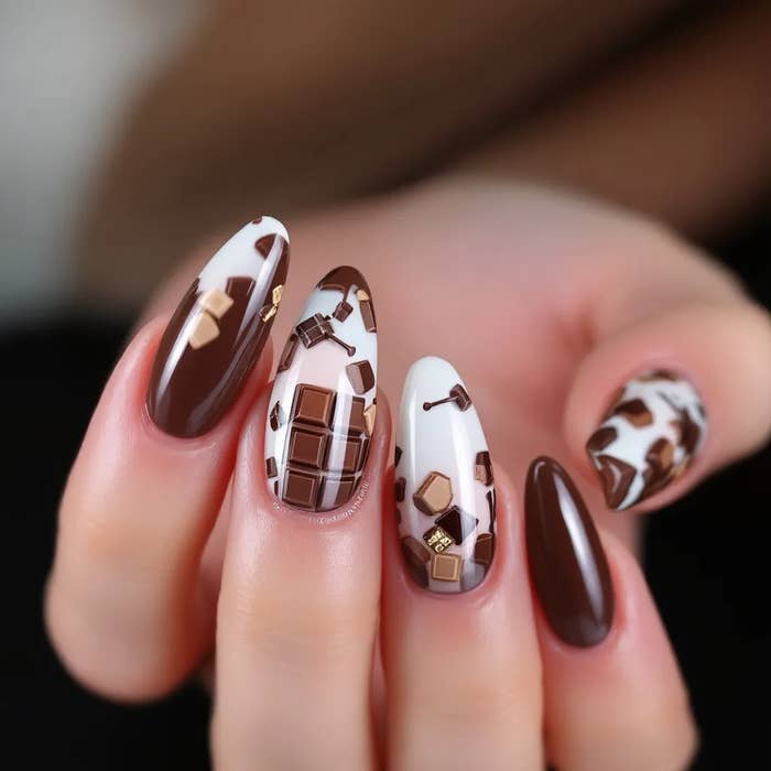 Nails with a detailed chocolate-themed design, featuring tiny chocolate bar patterns on a couple of nails