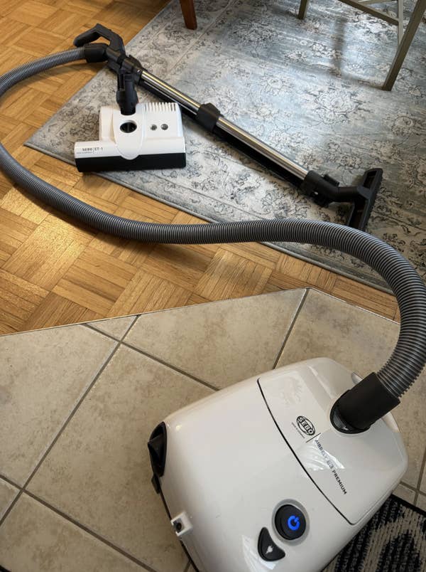 Screenshot of a Reddit post showing a vacuum cleaner on a rug, with comments discussing its purchase and performance
