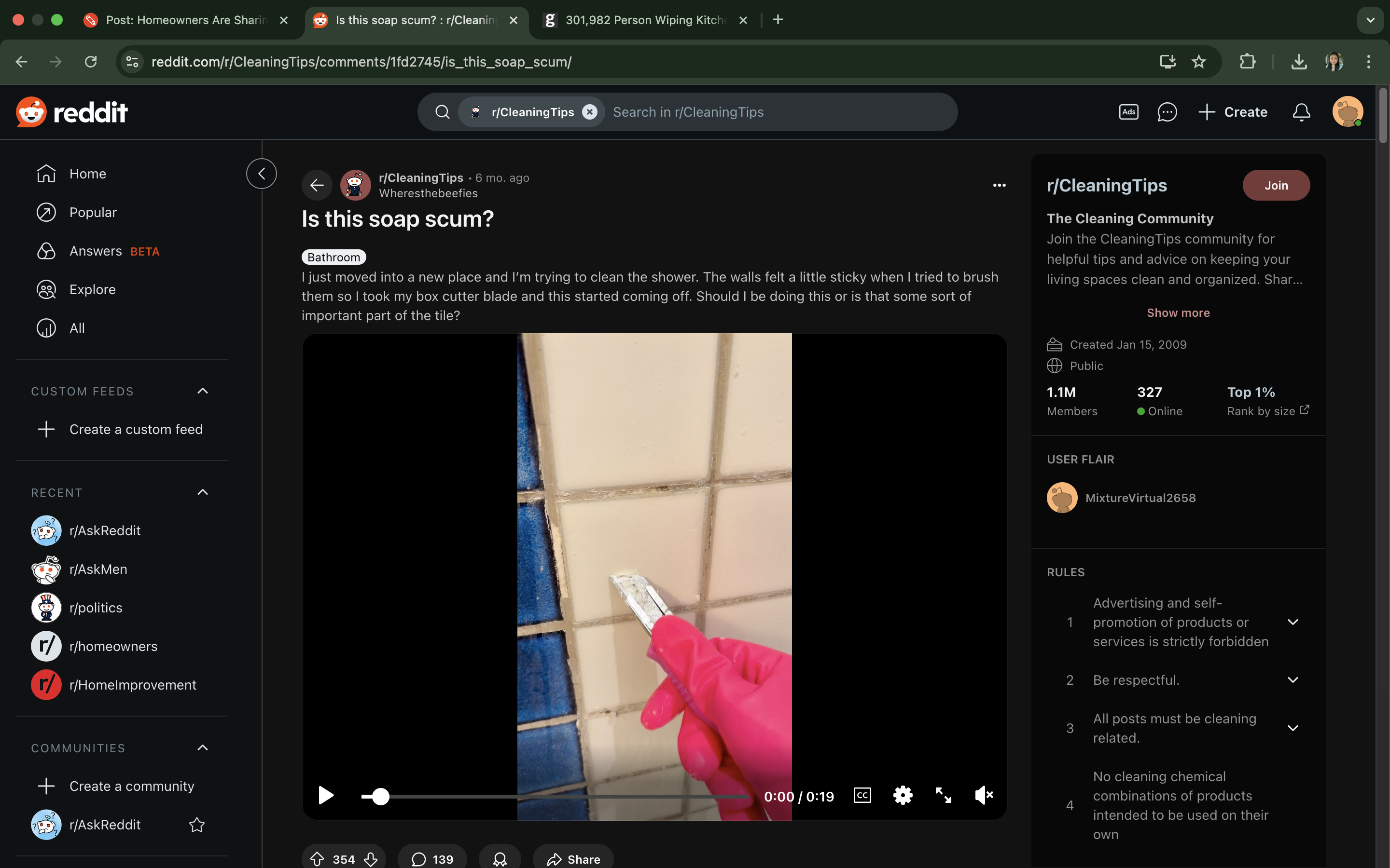 Reddit post showing a gloved hand cleaning tile grout with a razor blade. Viewer questions if it’s soap scum or important part of tile