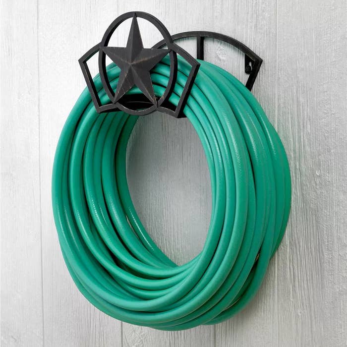 Garden hose neatly coiled connected  a wall-mounted holder with a prima  design