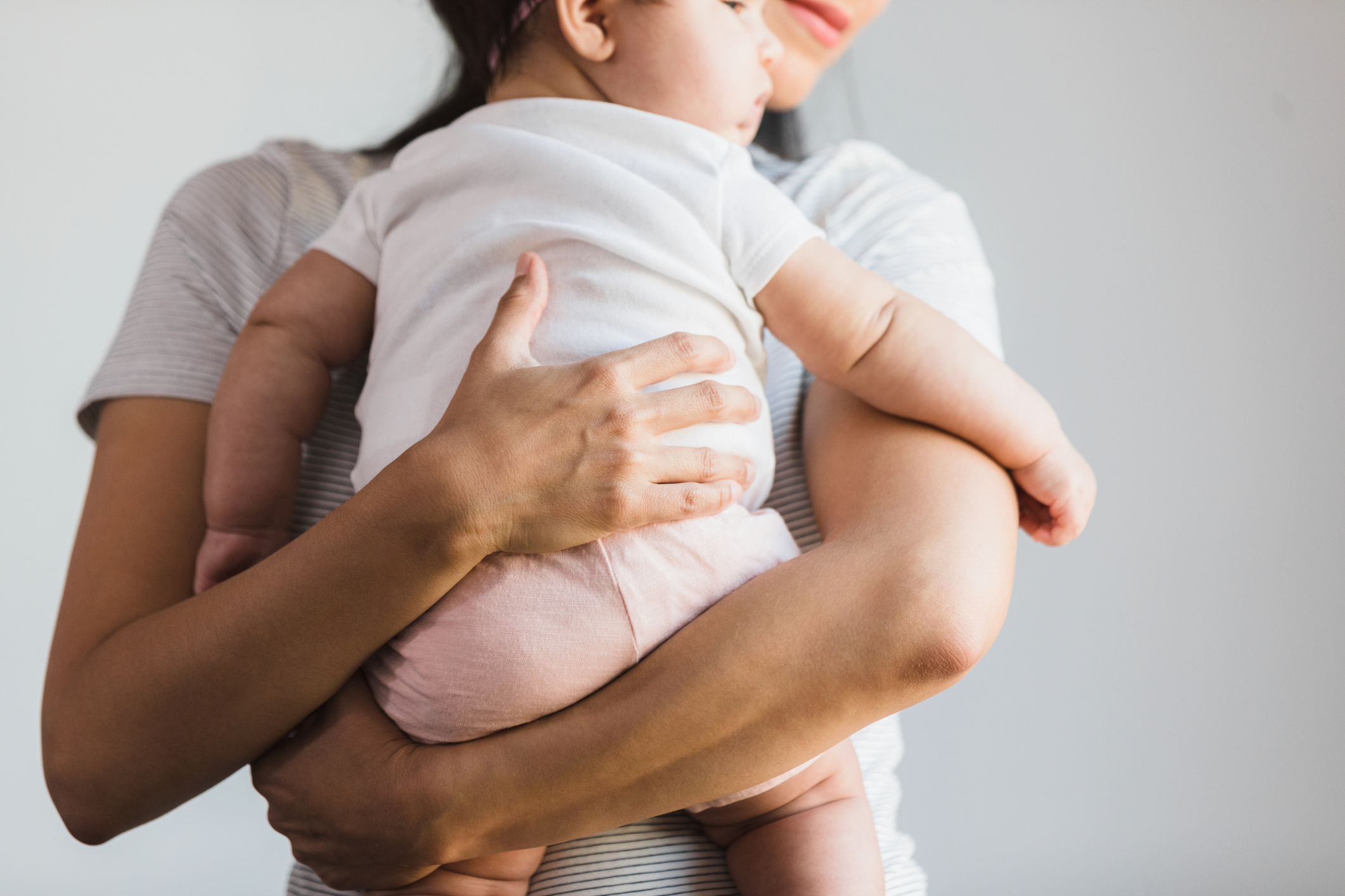 Personen holder en baby forsiktig, viser et ømt øyeblikk av liming og omsorg