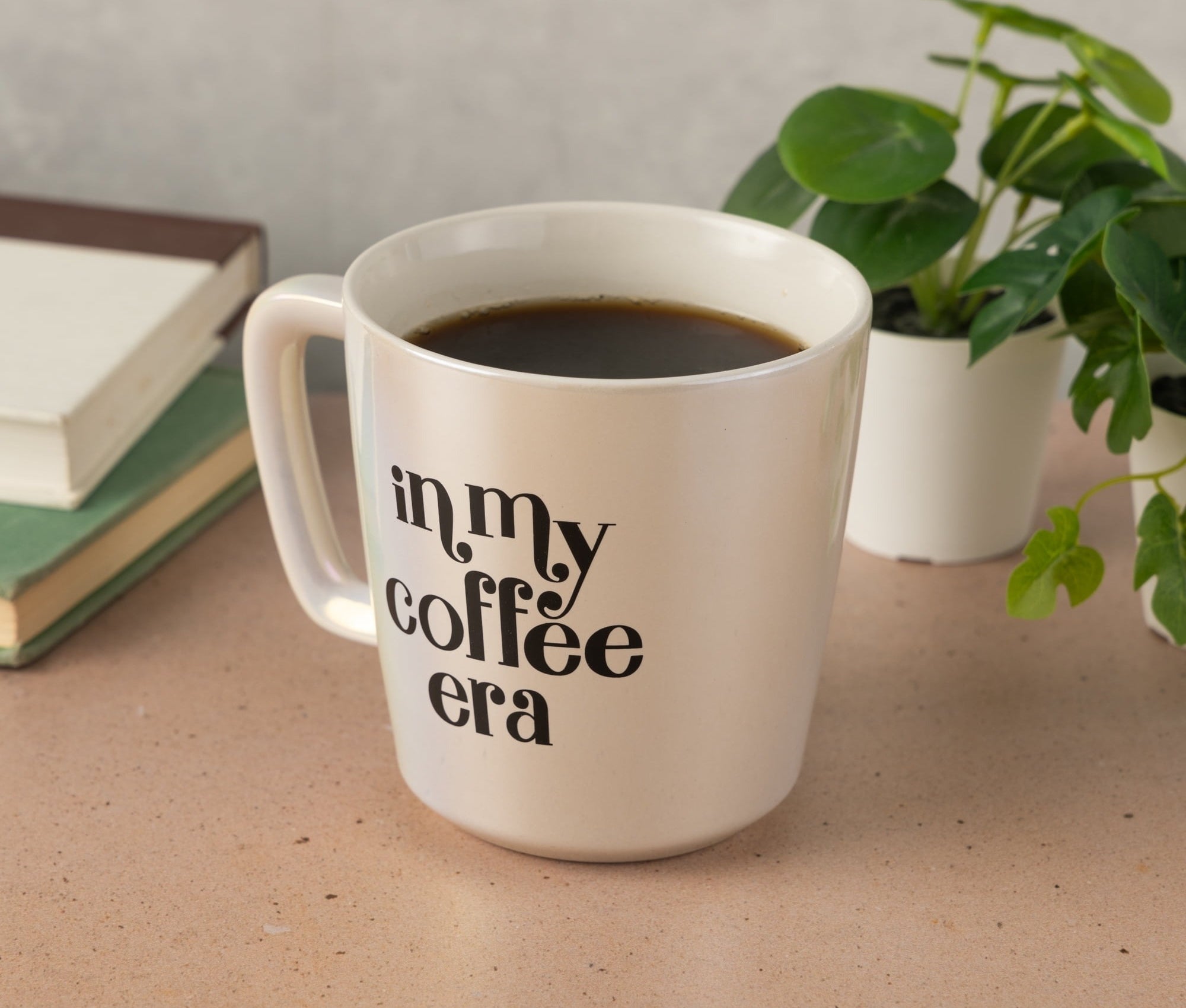 A white coffee mug on a table with the phrase &quot;in my coffee era&quot; printed on its side