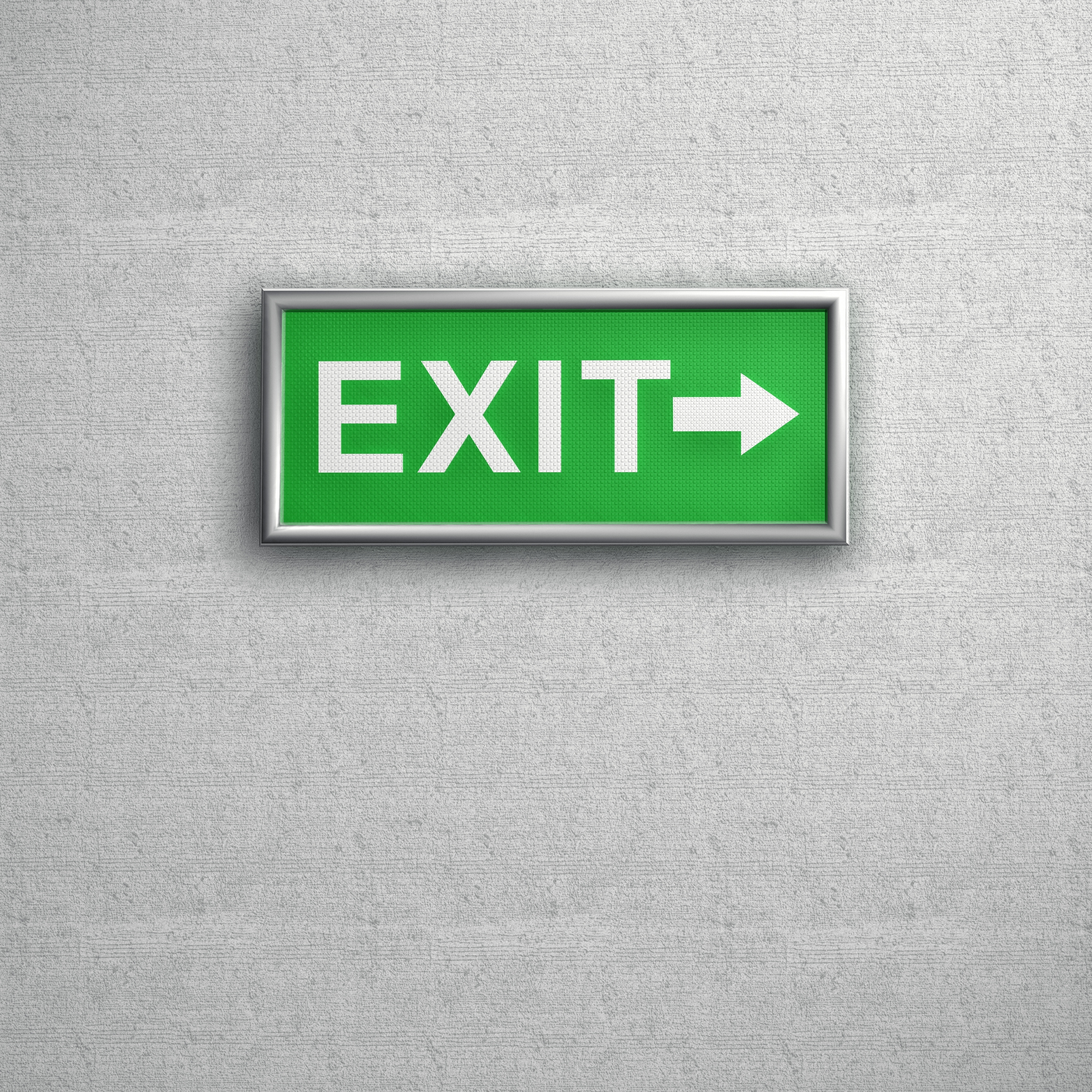 Exit sign on a wall with an arrow pointing right, indicating the direction to leave