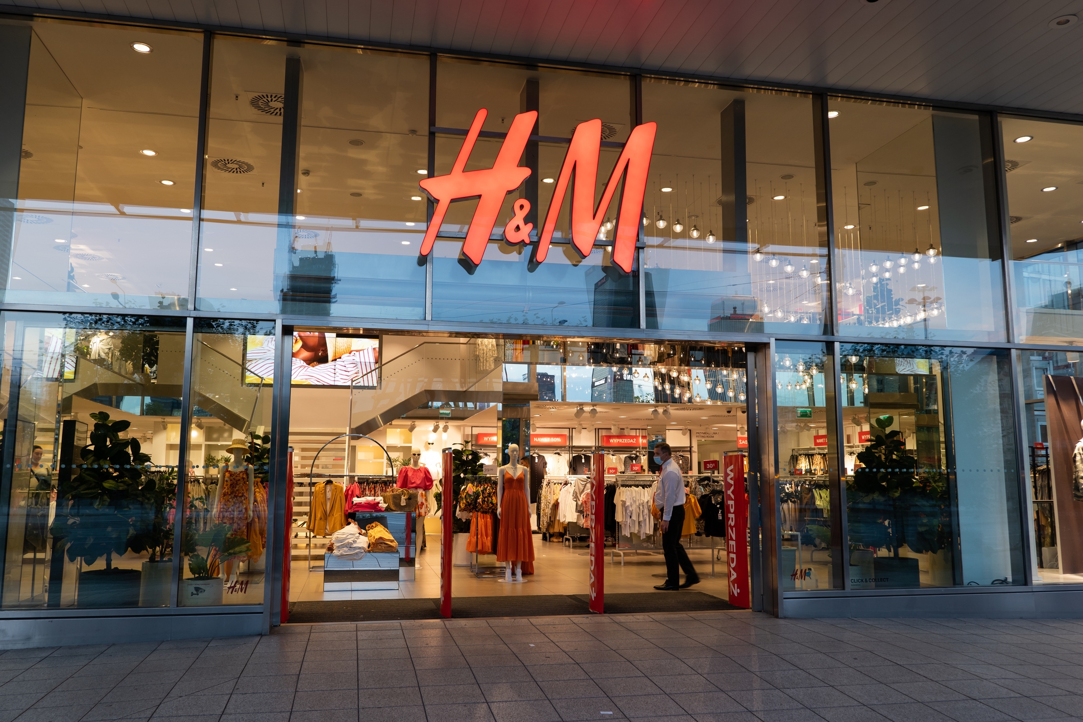 H & amp; amp; m Storefront med glassfasade som viser kjøpere og klesskjermer inne