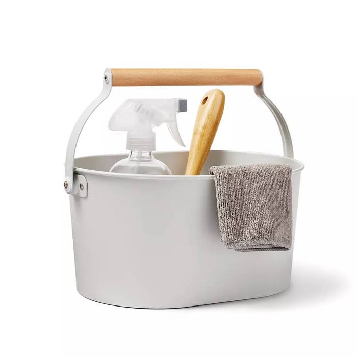 Cleaning kit with spray bottle, scrub brush, and cloth successful a achromatic bucket with a wood handle