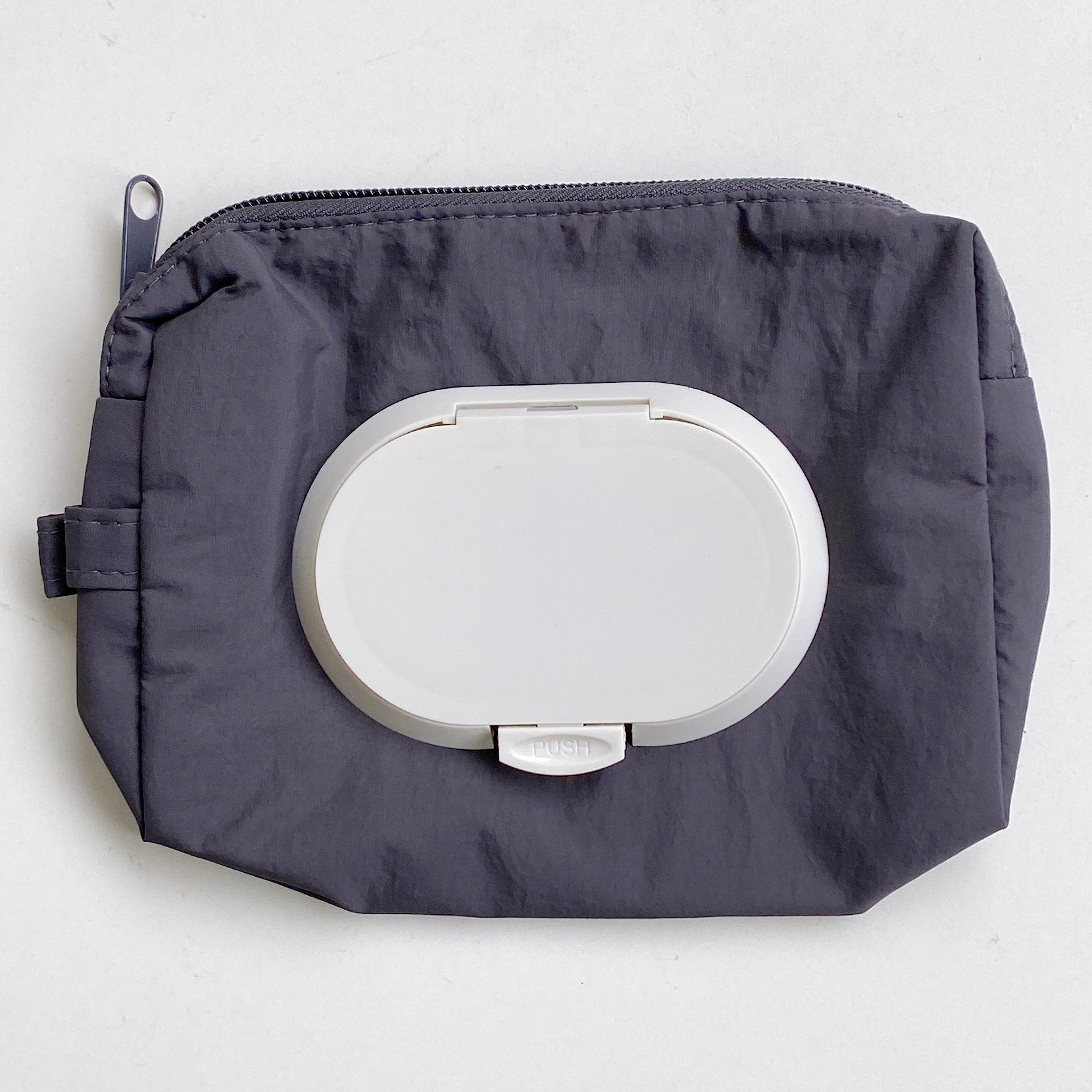 ファスナー付きポーチにティッシュディスペンサーが付いている商品。シンプルで実用的なデザイン。