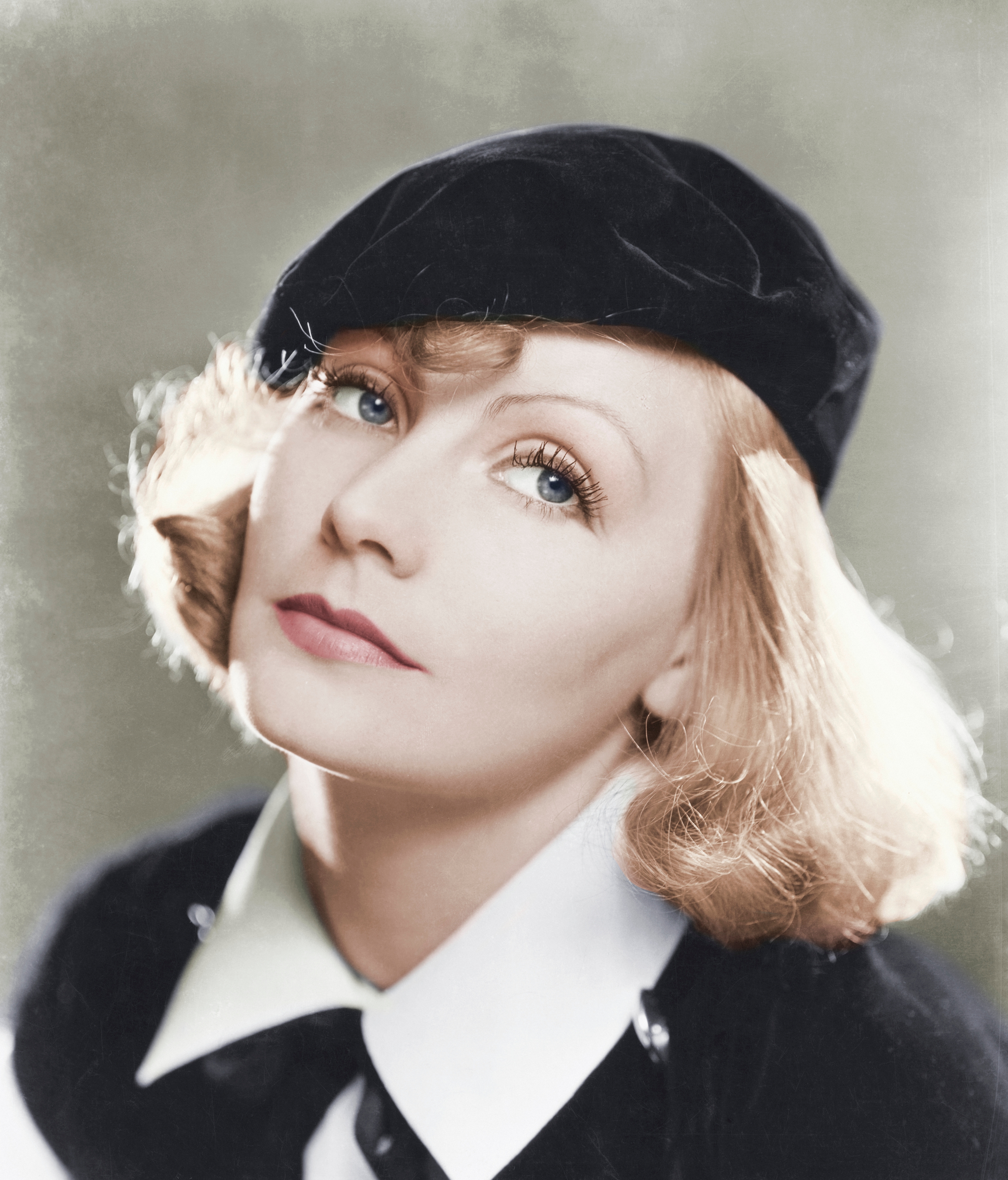 Person wearing a beret and classic outfit, with a contemplative expression and styled hair, gazing upwards