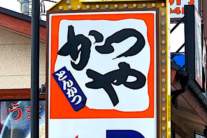 Sign with Japanese text and arrow points to parking near a restaurant offering a meal for 540 yen