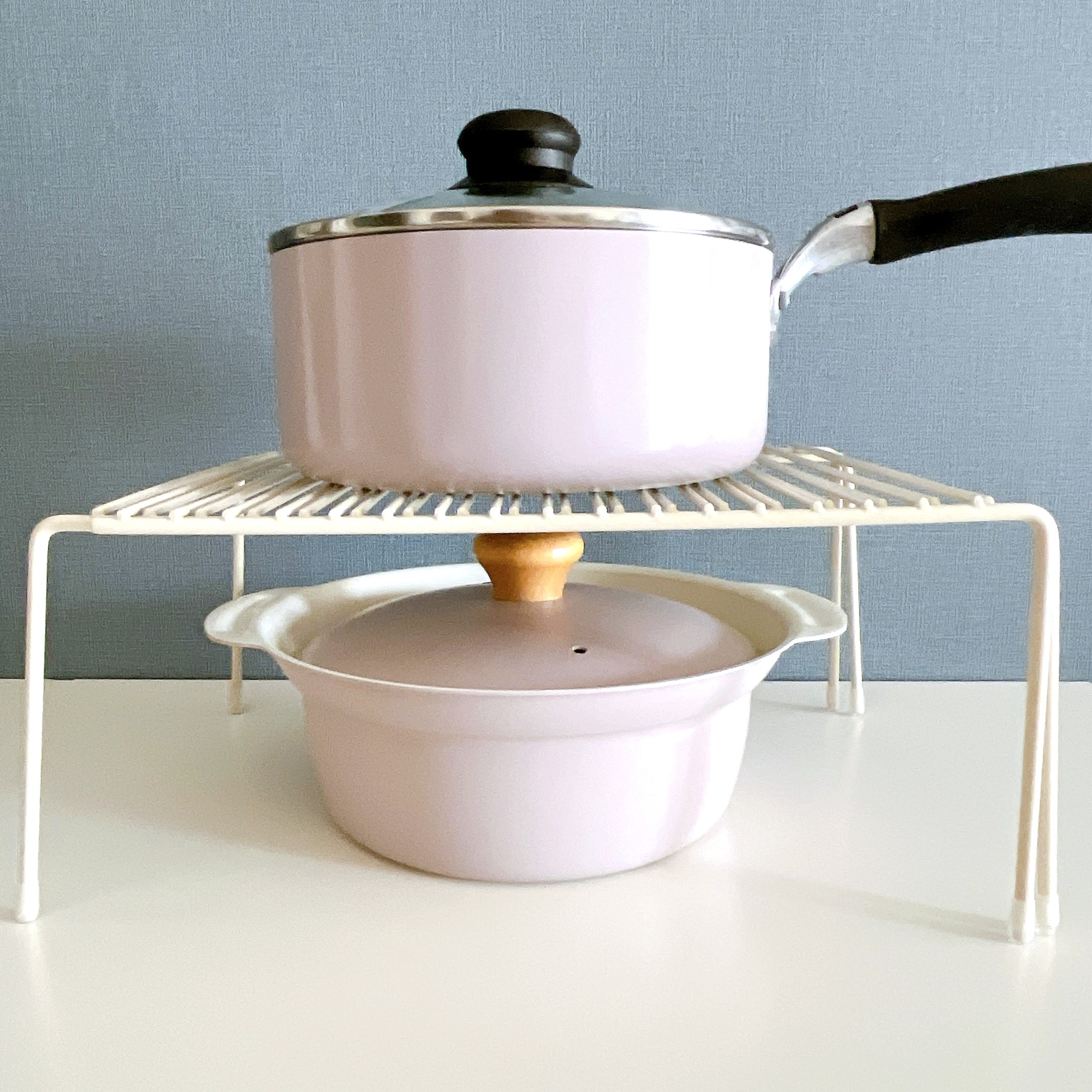 鍋がラックで上下に重ねられているキッチンのシーン。上は小さなソースパン、下は蓋付きのキャセロール。