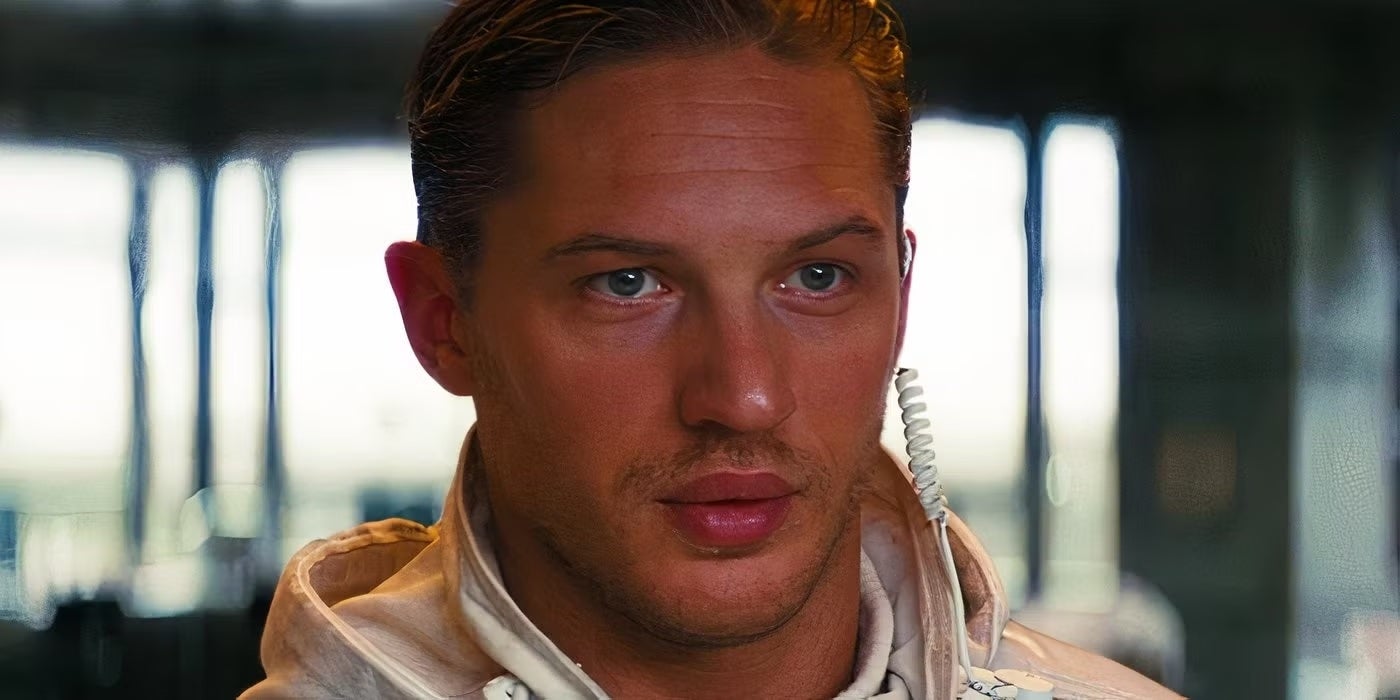 A person with a focused expression wears a high-collared garment, possibly in a scene from a film or TV show